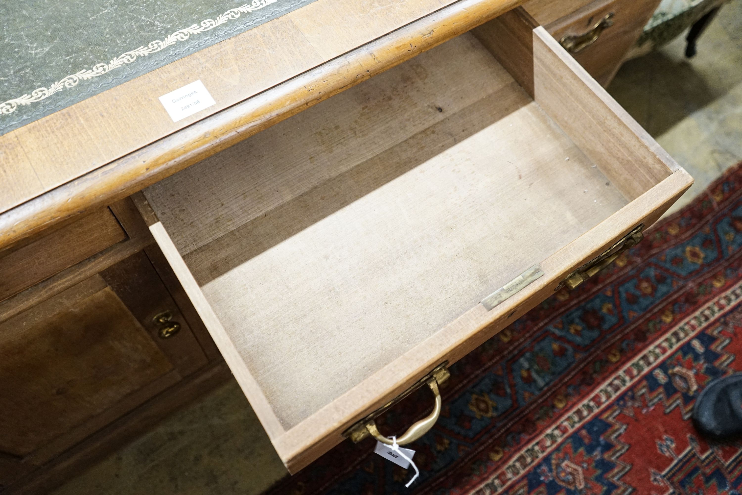 An Edwardian stripped beech pedestal desk, fitted eleven drawers, width 138cm, depth 80cm, height 76cm